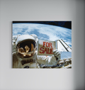 Kunstwerk SALE in einem modernen Wohnraum an der Wand: Astronaut Gardner mit FOR SALE Schild im Weltall, grossformatiger Fotodruck auf Alu-Dibond.